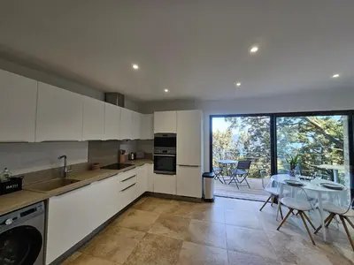 a kitchen with white cabinets and a table with chairs at U Paradisu in Piana