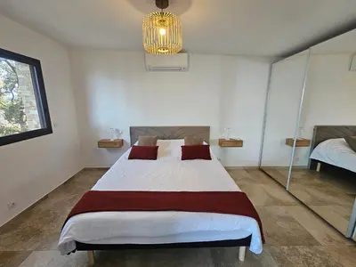 a bedroom with a large bed and a chandelier at U Paradisu in Piana