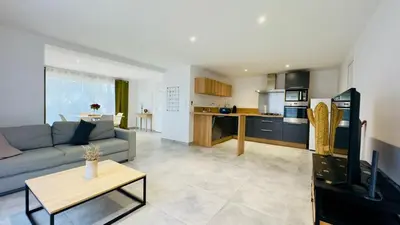 a large living room with a couch and a kitchen at CASA CUCCHI in Porto-Vecchio
