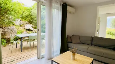 a living room with a couch and a table on a deck at CASA CUCCHI in Porto-Vecchio
