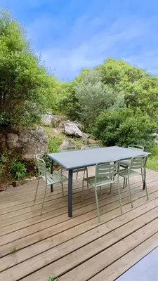 a blue table and two chairs on a wooden deck at CASA CUCCHI in Porto-Vecchio