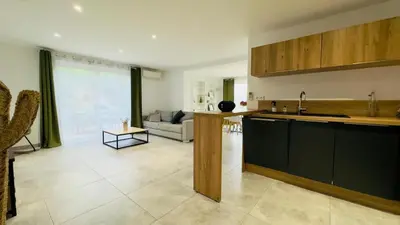 a kitchen with a counter top and a living room at CASA CUCCHI in Porto-Vecchio