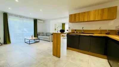 a kitchen with a sink and a living room at CASA CUCCHI in Porto-Vecchio