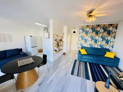 a living room with a blue couch and a table at Grand Studio terrasse vue sur mer et parking in Ajaccio