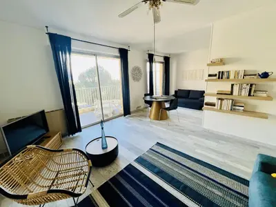 a living room with a couch and a television at Grand Studio terrasse vue sur mer et parking in Ajaccio