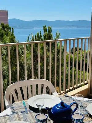 a table with a tea pot on top of a balcony at Grand Studio terrasse vue sur mer et parking in Ajaccio