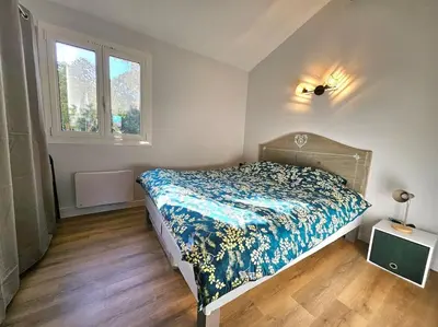 a bedroom with a bed with a blue comforter at Mini Villa Bord de Mer - Idylle BY MONARCA in San-Nicolao