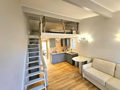a living room with a couch and a loft bed at Mini Villa Bord de Mer - Idylle BY MONARCA in San-Nicolao
