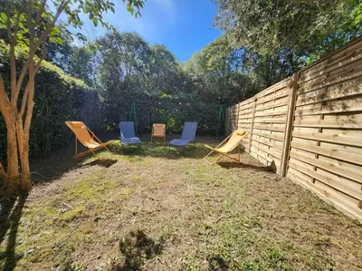three chairs and a fence in a yard at Mini Villa Bord de Mer - Idylle BY MONARCA in San-Nicolao