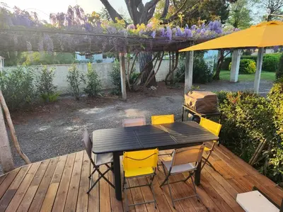 a table and chairs on a deck with an umbrella at Mini Villa Bord de Mer - Idylle BY MONARCA in San-Nicolao