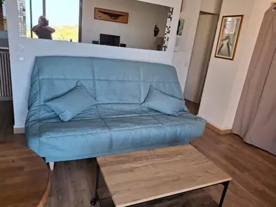 a blue couch in a living room with a table at TERRA BELLA 2 in Grosseto-Prugna