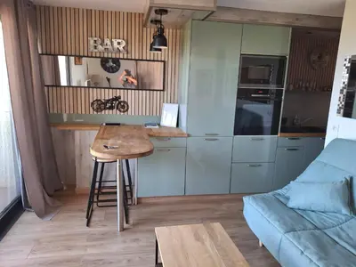 a small kitchen with a table and a blue couch at TERRA BELLA 2 in Grosseto-Prugna