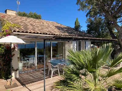 a house with a deck with a table and chairs at VILLA LES GORGONES - Corse du Sud - Vue mer - 200m plage in Zonza