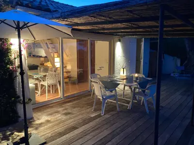 a patio with a table and chairs and an umbrella at VILLA LES GORGONES - Corse du Sud - Vue mer - 200m plage in Zonza