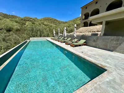 a swimming pool with chairs and umbrellas next to a building at CASA ALTEZZA in Soveria