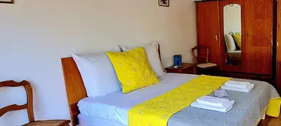 a bedroom with a bed with yellow and white pillows at La Bergerie de Pauline - Bord de mer, vue unique in Pianottoli-Caldarello
