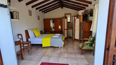 a bedroom with a bed with a yellow blanket at La Bergerie de Pauline - Bord de mer, vue unique in Pianottoli-Caldarello