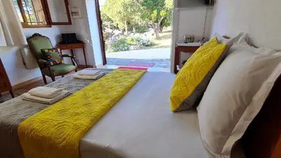 a large bed with yellow sheets and pillows on it at La Bergerie de Pauline - Bord de mer, vue unique in Pianottoli-Caldarello
