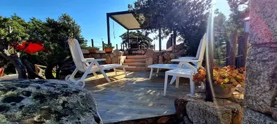 two white chairs sitting on a wooden patio at La Bergerie de Pauline - Bord de mer, vue unique in Pianottoli-Caldarello