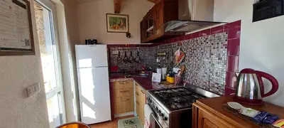 a kitchen with a stove and a white refrigerator at La Bergerie de Pauline - Bord de mer, vue unique in Pianottoli-Caldarello
