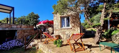 a group of chairs sitting in front of a house at La Bergerie de Pauline - Bord de mer, vue unique in Pianottoli-Caldarello