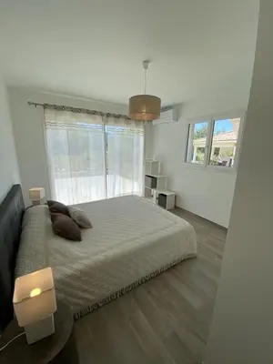a bedroom with a large bed and a large window at Villa Piazzola in Petreto-Bicchisano