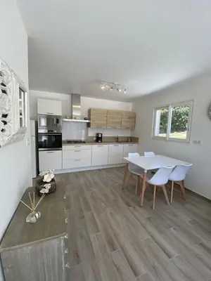 a large white kitchen with a table and chairs at Villa Piazzola in Petreto-Bicchisano