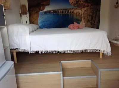 a bed in a room with a painting on the wall at la loggia in Porto-Vecchio