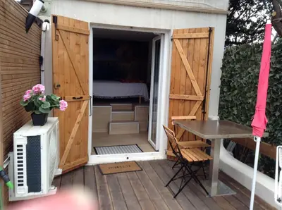a door leading to a patio with a table and a bed at la loggia in Porto-Vecchio