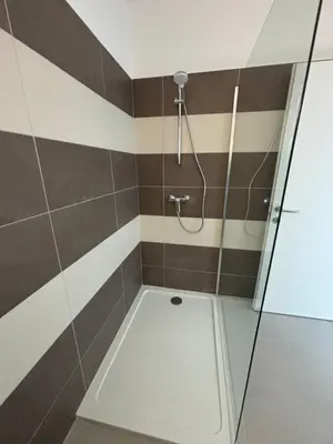 a bathroom with a shower with brown and white stripes at Bel appartement T2 proche centre-ville et port in Porto-Vecchio