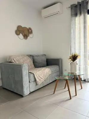 a living room with a couch and a table at Bel appartement T2 proche centre-ville et port in Porto-Vecchio