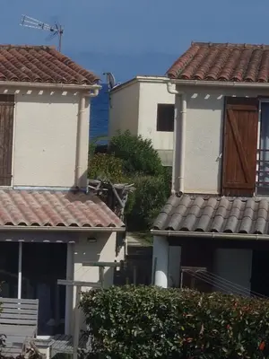 two houses with red roofs and the ocean in the background at Villa Frati in Poggio-Mezzana