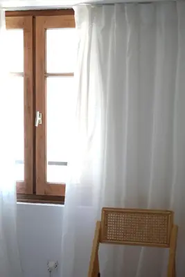 a window with a white curtain in a room at HÖTEL U SANTA MARIA in Olmeto