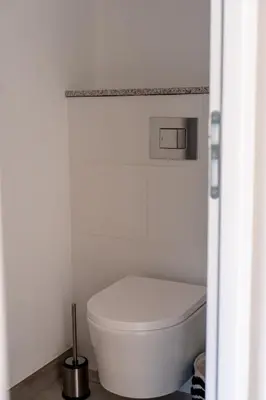 a bathroom with a white toilet in a room at Casa Léa in Sollacaro