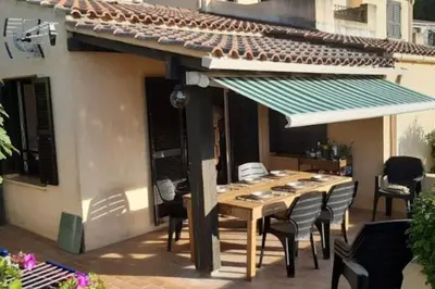 a wooden table and chairs on a patio at Location Appartement Porticcio in Grosseto-Prugna