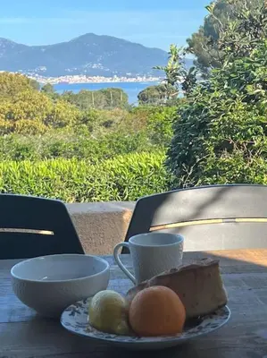 a table with a plate of food and cups on it at Location Appartement Porticcio in Grosseto-Prugna