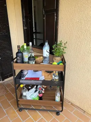 a cart full of bottles of alcohol on a porch at Location Appartement Porticcio in Grosseto-Prugna
