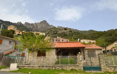 a house with a fence in front of a mountain at 2 Bedroom Stunning Home In Popolasca in Popolasca