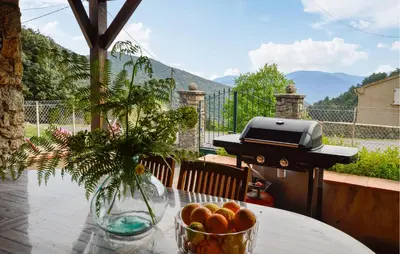 a table with a bowl of fruit and a grill at 2 Bedroom Stunning Home In Popolasca in Popolasca