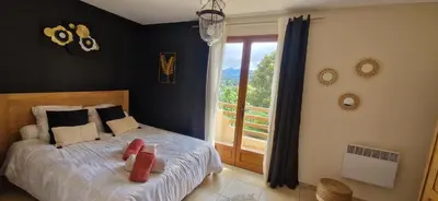 a bedroom with a bed and a large window at Mare e Monti Chez Thomas et Magali in Vico