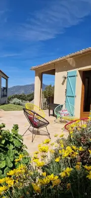 a patio with two chairs and flowers in front of a house at Mare e Monti Chez Thomas et Magali in Vico