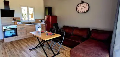 a living room with a couch and a table and a clock at Bergerie A Sapara in Pianottoli-Caldarello