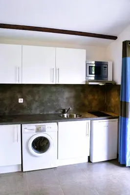 a kitchen with a washing machine and a microwave at E Casette Di Santa Giulia in Porto-Vecchio