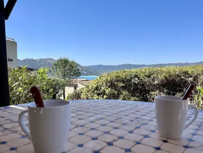 two cups on a table with a view of the ocean at E Casette Di Santa Giulia in Porto-Vecchio