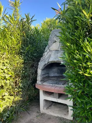 a stone bench sitting next to some bushes at E Casette Di Santa Giulia in Porto-Vecchio