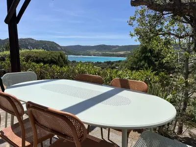 a white table and chairs with a view of a lake at E Casette Di Santa Giulia in Porto-Vecchio