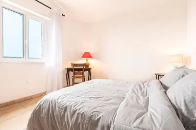 a white bedroom with a bed and a window at Bergerie Piattone - Maison avec grand jardin in Pianottoli-Caldarello