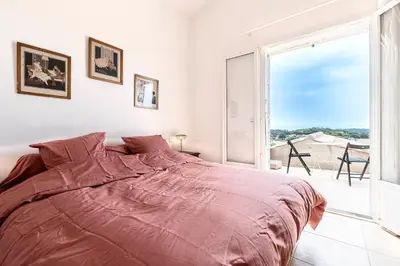 a bedroom with a large bed and a large window at Bergerie Piattone - Maison avec grand jardin in Pianottoli-Caldarello