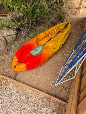 a yellow kayak laying on the ground next to a net at Chalet maisonette dans hameau calme in Bonifacio