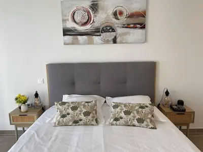 a bedroom with a white bed with two pillows at Villa La Rondina vue mer, piscine et plage à pied. in Zonza